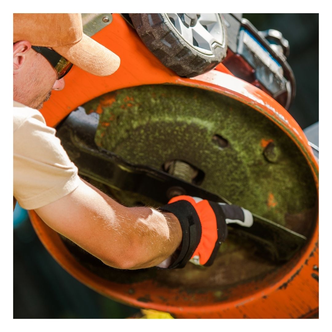 person checking lawn mower blades